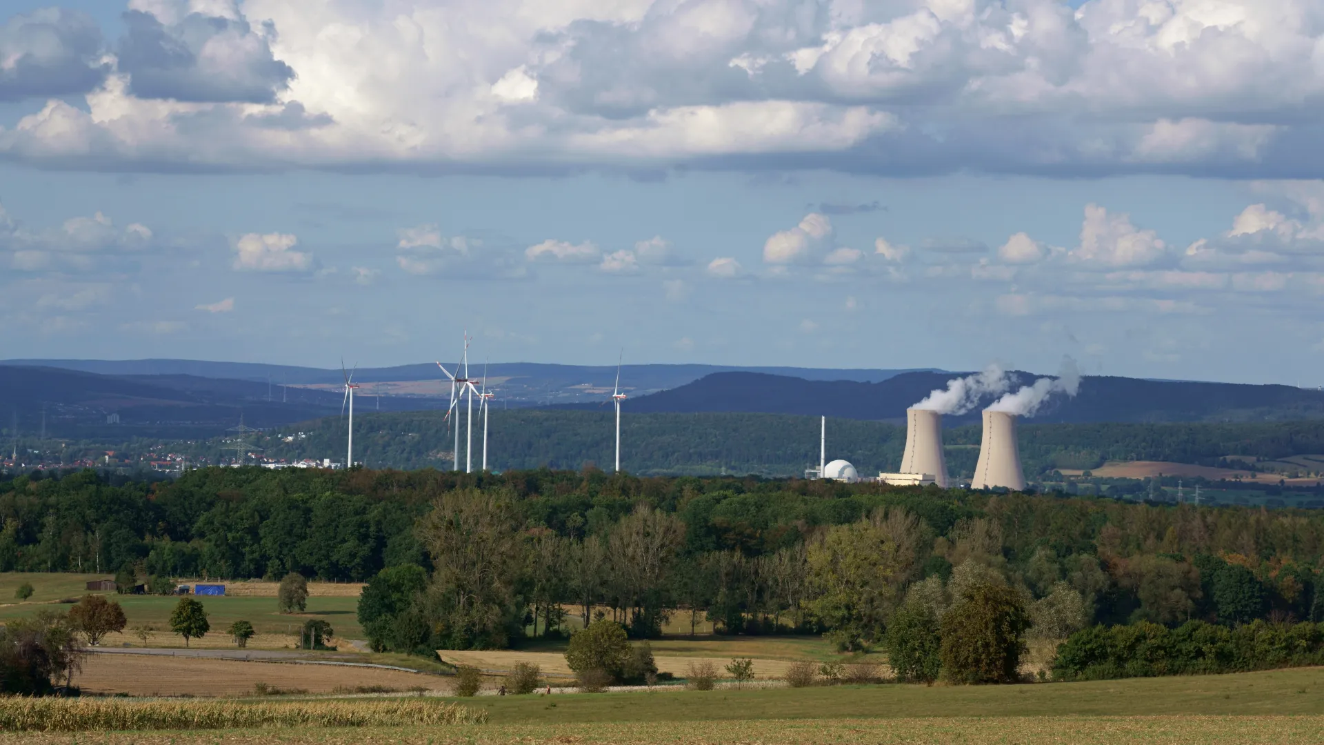 Atomkraftwerk neben Windrädern